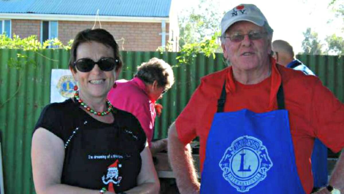 REELECTED: President Anne Holden and Lions Club's Geoff Terry at a successful TAG Christmas Party looking after the barbecue. Photo: FILE. 