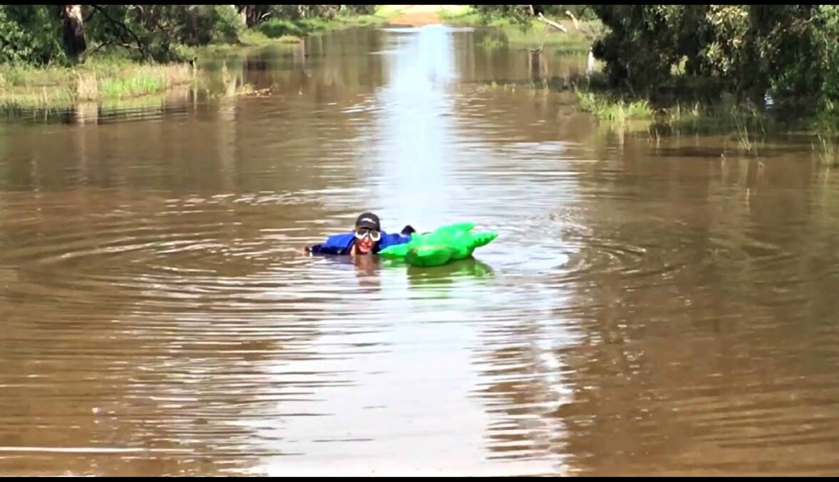 ROAD SWIMMING: Father and farmer Greg Broughton can put his head under water on the Jamea Road, and does so on the video shown to council. Photo: VIDEO SCREENSHOT. 