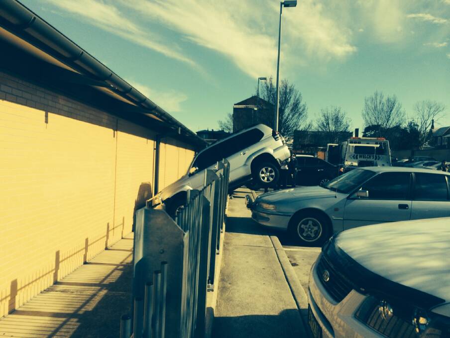 SINKING FEELING: This Toyota Prado 4WD came to a precarious rest after a parking mishap at Bathurst Aldi. Photo: TOP NOTCH VIDEO	 081014aldi2