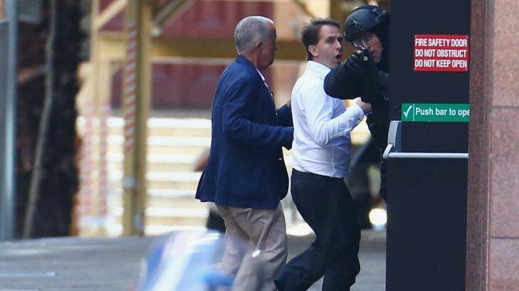 Two hostages run to safety after being freed from the cafe.  Photo: Mark Metcalfe
