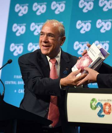 Treasurer Joe Hockey holds up a report with OECD secretary-general Angel Gurria (L) at the G20 Finance Ministers and Central Bank Governors Meeting in Cairns.