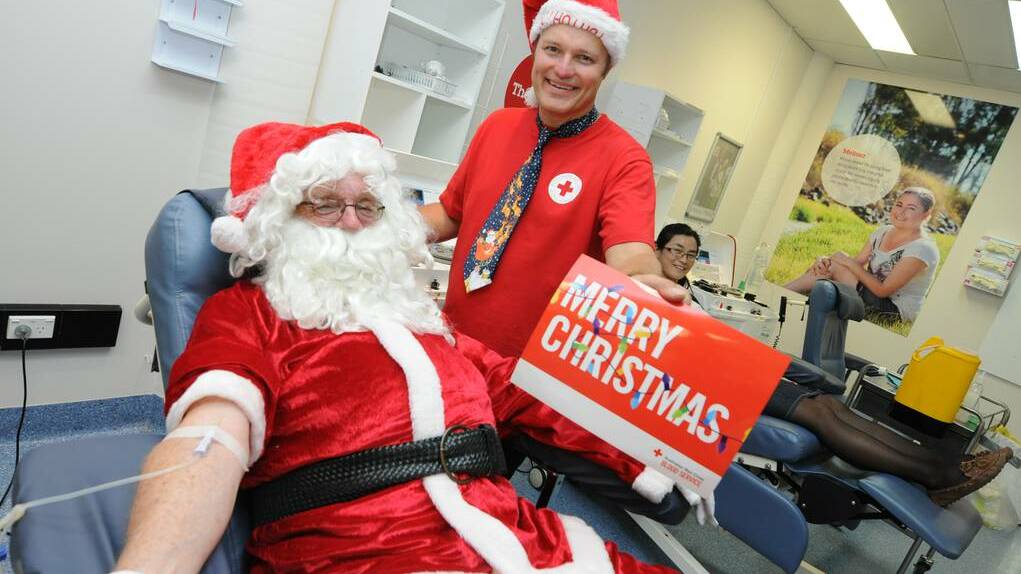 Santa giving blood at Taree Blood Bank as part of the Blood Blitz., assisted by Greg French of the Red Cross Blood Service.