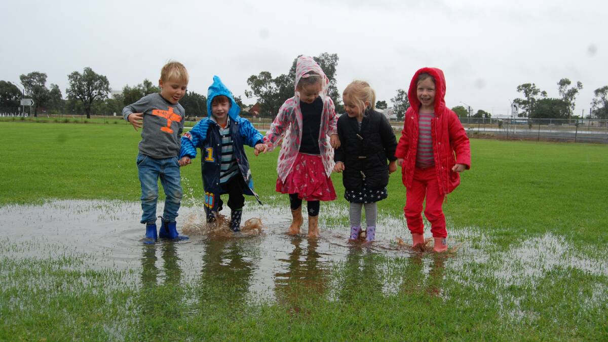Bill, Cooper, Lola, Winnie and Hope play in the puddles at Narromine Christian School as they attend for pre-kinder. Photo: Grace Ryan.