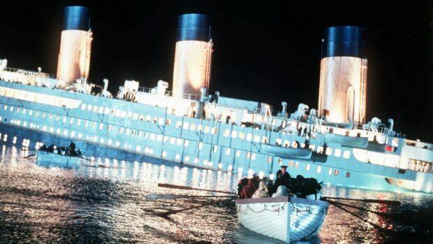 Passengers row to safety aboard a lifeboat as the ill-fated ship sinks in Titanic. Photo: Merie W. Wallace
