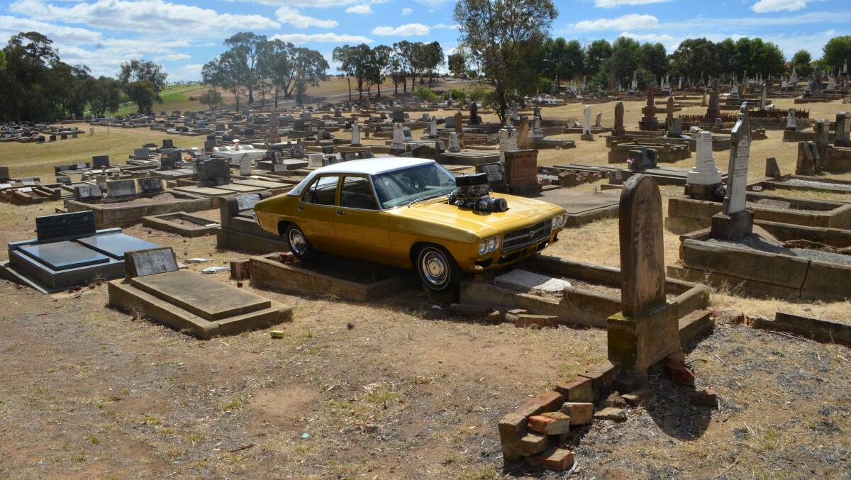 The gold HX Premier Kingswood Sedan that broke free of the tie-down points on its trailer and ended up on top of graves in Young's monumental cemetery.