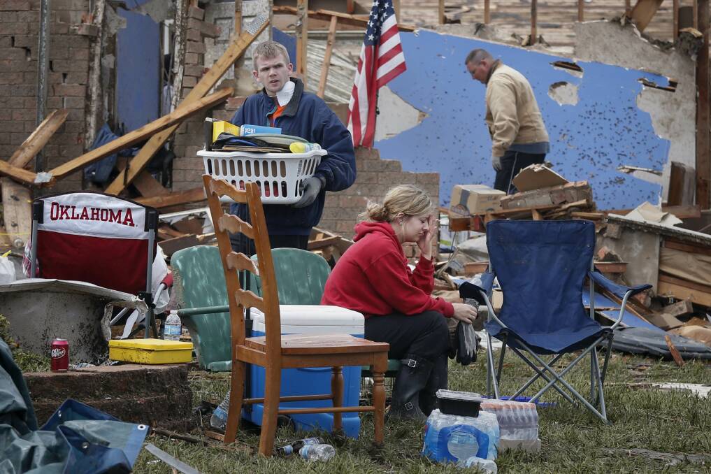 Resident Taylor Tennyson sits in the front yard as family members salvage the remains from their home which was left devastated by a tornado in Moore, Oklahoma, in the outskirts of Oklahoma City May 21, 2013. Photo: REUTERS/Adrees Latif