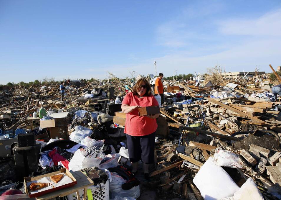 Kelli Kannady weeps after finding a box of photographs of her late husband in the rubble near what was her home in Moore, Oklahoma May 21, 2013. Photo: REUTERS/Rick Wilking
