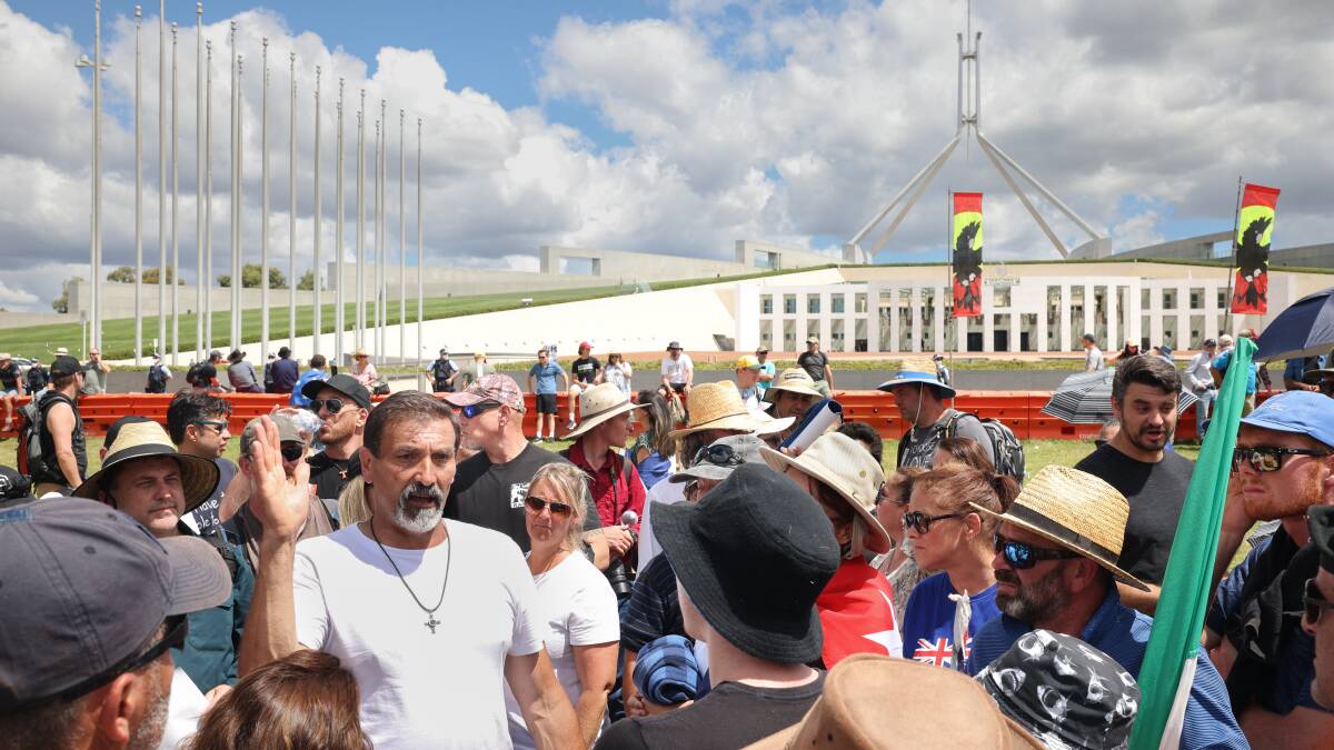 Hardline conspiracist Riccardo Bosi (in white shirt) speaks to supporters on Saturday. Picture: Sitthixay Ditthavong