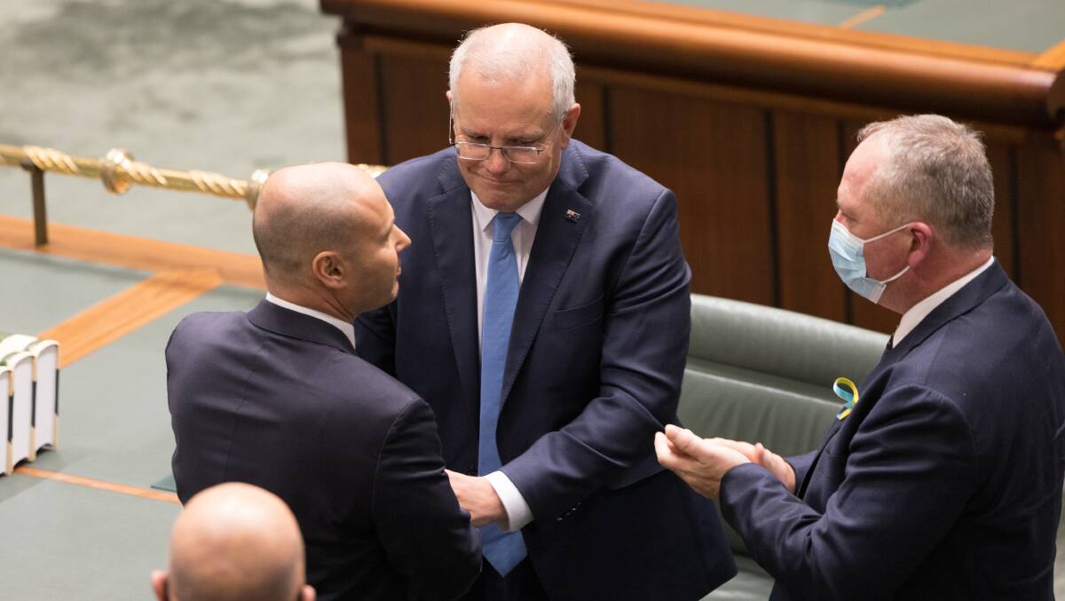 Scott Morrison and Barnaby Joyce congratulate Treasurer Josh Frydenberg after delivering the budget. Picture: Sitthixay Ditthavong