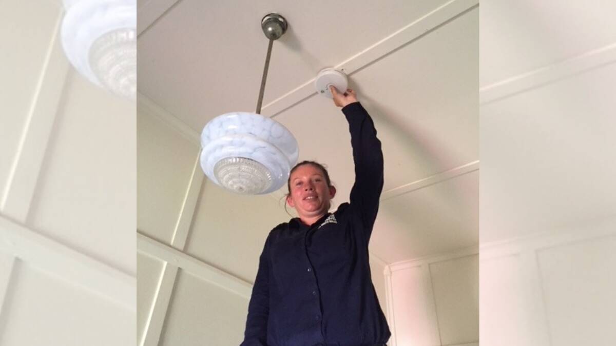Narromine Retained Firefighter Cirtrine Fraser testing a smoke alarm as part of the FRNSW Home Fire safety checks. Photo: CONTRIBUTED