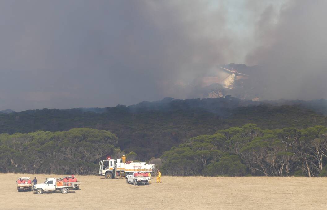 FIRE BOMBER: A fire-bombing air tanker drops its load between the smoke at the fire at Redbanks on Kangaroo Island. Photo Stan Gorton 