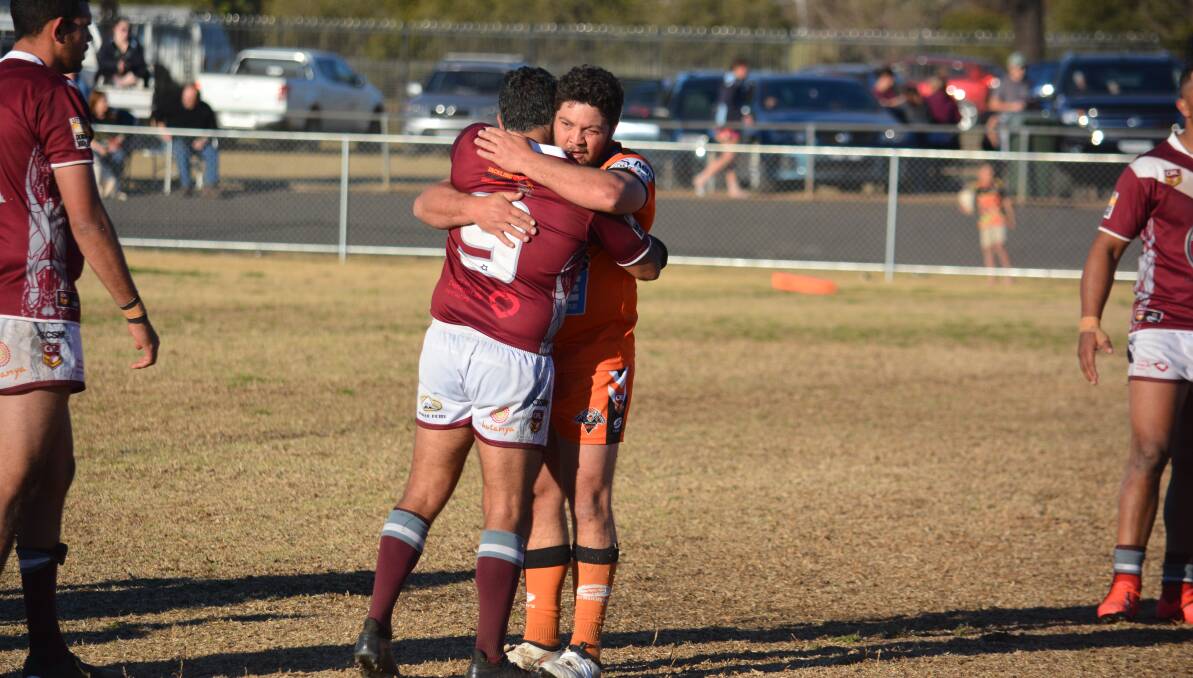 TOGETHER: Nyngan's Josh Merritt and Dennis Moran embrace after a finals clash last year. The clubs could be back on the park in July. Photo: NICK GUTHRIE