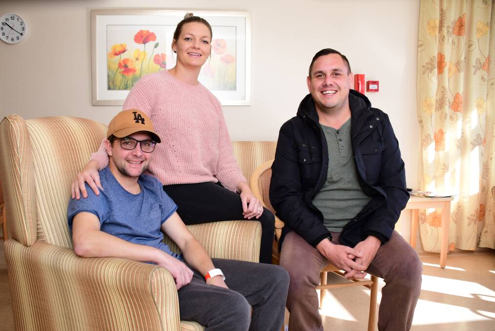 Improving: Jockey Michael Hackett with wife Lee and friend Ben Smith in Lourdes Hospital, where he is continuing his recovery from a fall from his horse at the Tomingley races in April. Photo: BELINDA SOOLE