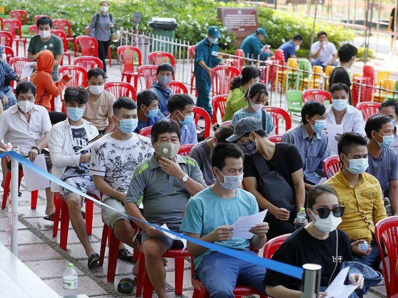 People wait to receive a shot of AstraZeneca vaccine in Hanoi, Vietnam.